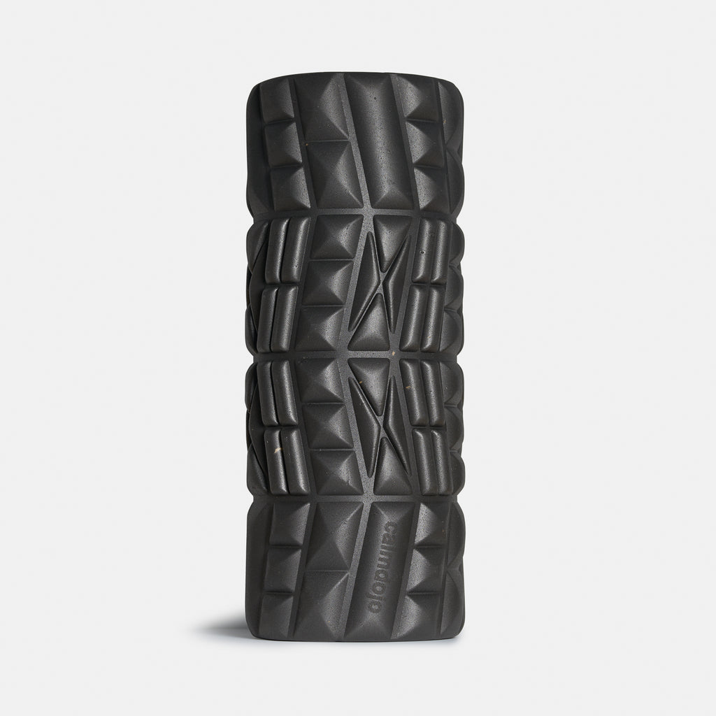 black foam roller standing on its head with surface ridges visible.