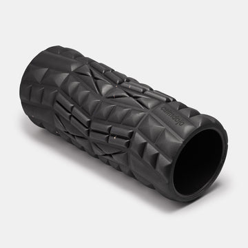 three quarter view of black foam roller with calmdojo brand logo  laser engraved  and textured surface visible against a white background.