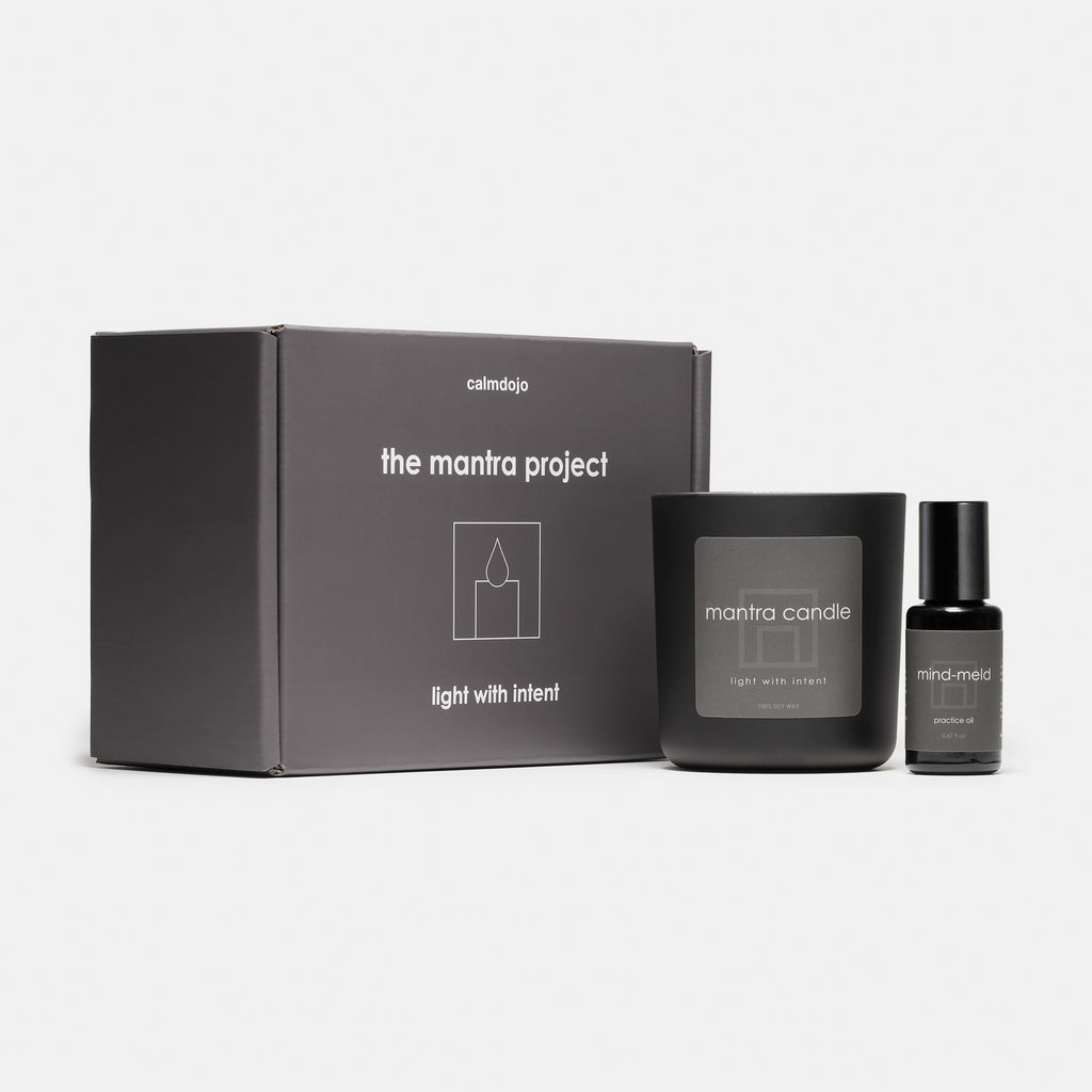 Gray mantra project kit box with black jar candle and mind-meld product in black glass bottle.