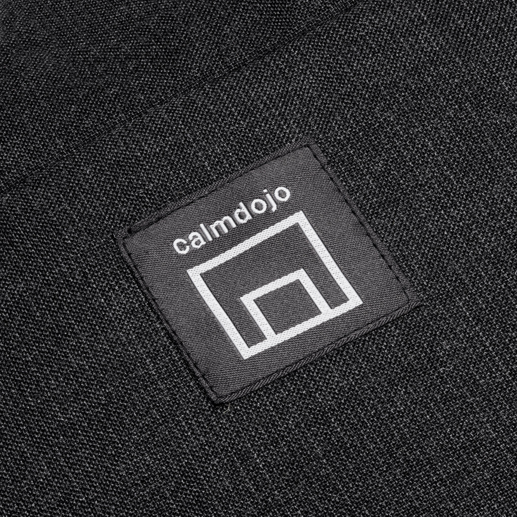 closeup of calmdojo logo against the gray surface of heart shaped pillow.