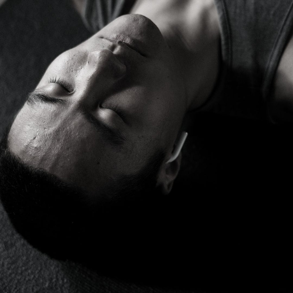 young asian male adult with headphones meditating.