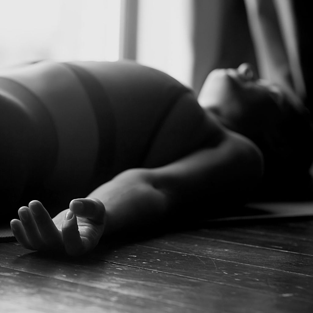 young woman resting in savasana